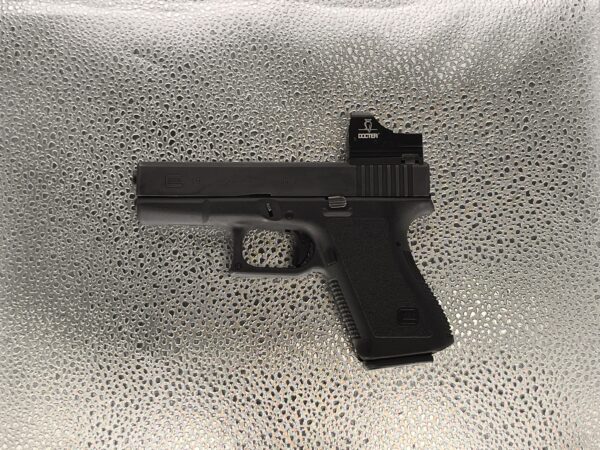 Pistolet Glock 19 kaliber 9 mm z kolimatorem Docter, kompaktowy model z polimerowym szkieletem.